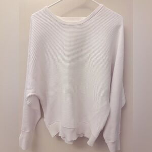 White open back long sleeve shirt, loose fit at the body, tighter at the hip,